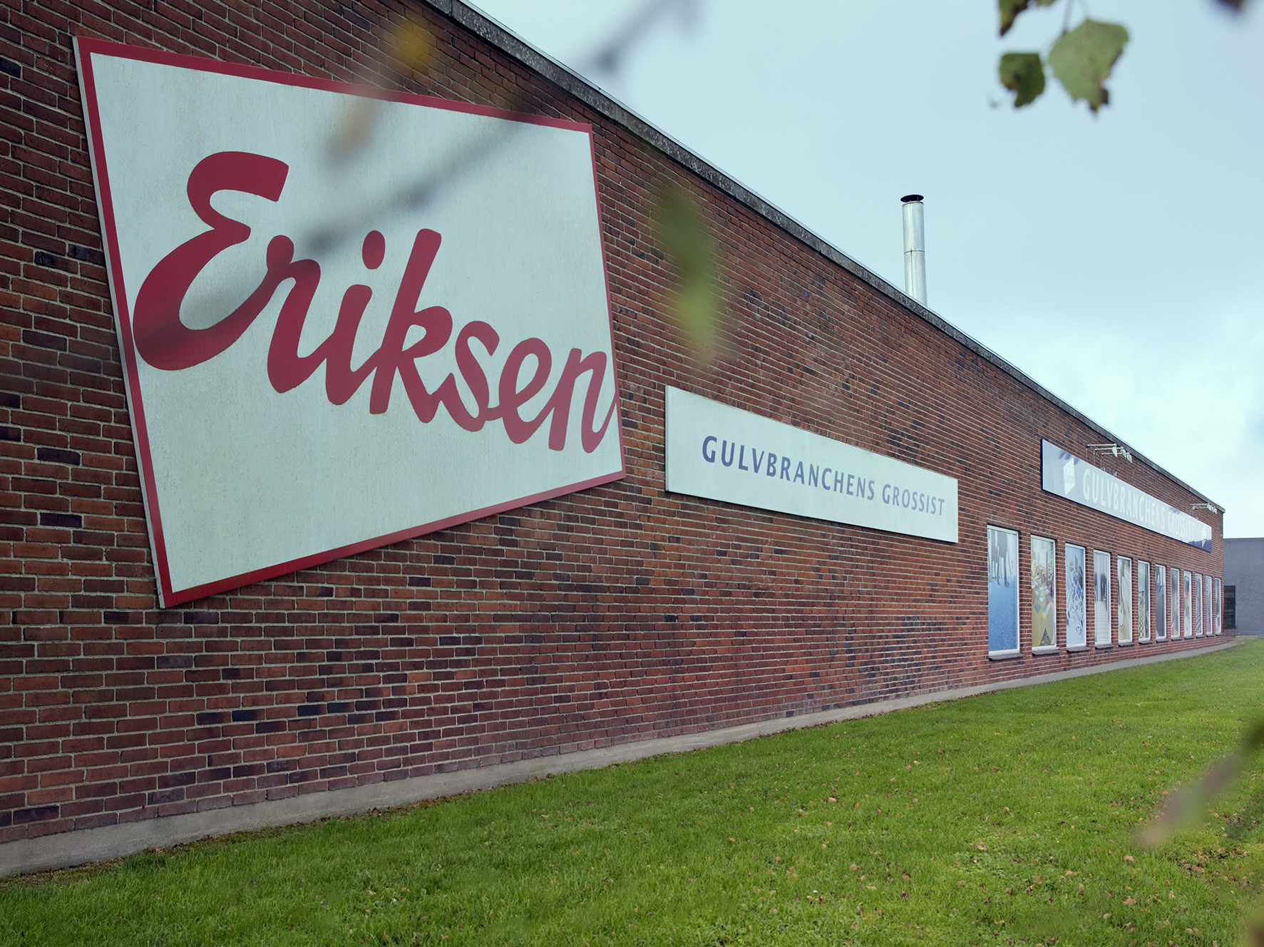 Er billede af bygningen set udefra hvor der står Eriksen Gulvbranchens grossist på vægen